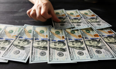 Girl Hands Arranging One Hundred Dollar Bills On A Table