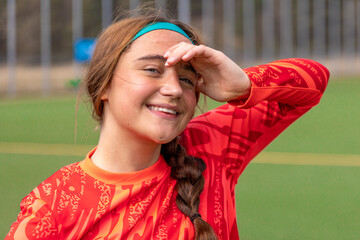 Smiling girl soccer player. Girl in sports uniform on the soccer field. Football concept.