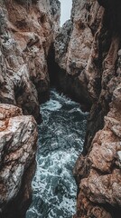 Obraz premium Dramatic ocean waters flowing between towering coastal rock formations scenery