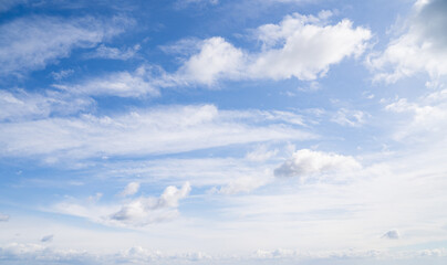 Very bright blue sky with scattered white puffy clouds on sunny day. Sun is shining brightly. Sky...