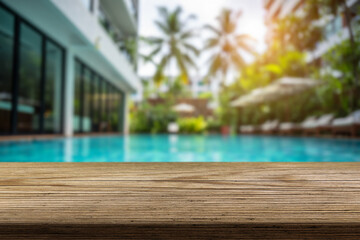 Calm poolside view with wooden deck and lush greenery under sunlight in a tropical setting