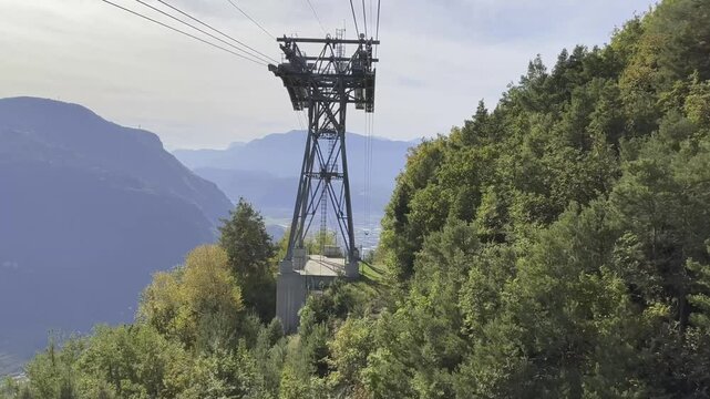 Eine Seilbahnstation &uuml;berblickt ein Tal und zeigt eine weite Aussicht &uuml;ber Berge und einen bewaldeten Hang, Video, Oberbozen, Bozen, S&uuml;dtirol, Italien