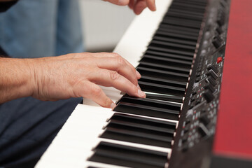 Fototapeta premium Musician plays piano with skillful hands in an indoor studio setting during an intimate practice session