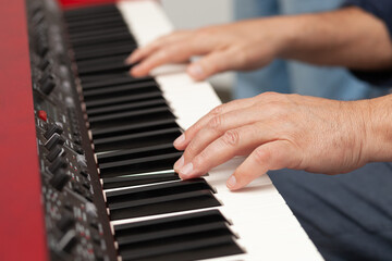 Obraz premium Music creation process in a cozy space with hands playing an electronic keyboard instrument