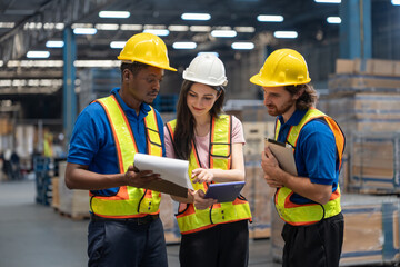 Diverse group of warehouse workers woman and men discussing and reviewing documents with tablet for...