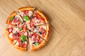 Tasty pizza with thin smoked sausages on wooden table, top view. Space for text