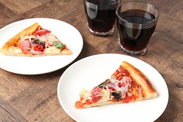 Slices of tasty pizza with thin smoked sausages served on wooden table, closeup