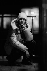 Portrait of a young beautiful girl in warm clothes in the night city.