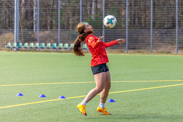 Girl on the soccer field. Soccer training. Active lifestyle. Football concept.