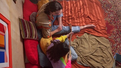 Young People Enjoying Music and Relaxing in Cozy Bedroom Setting