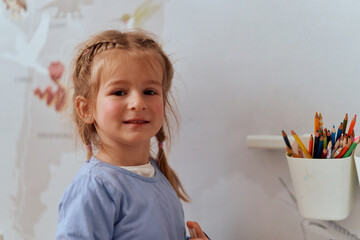 Fototapeta premium Girl Drawing in the Warmth of Her Room, Expressing Creativity and Imagination.