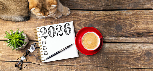 New year resolutions 2026 on desk. 2026 resolutions list with notebook, coffee cup, cute cat on table. Goals, resolutions, plan, cozy, hygge concept. New Year 2026 template, copy space
