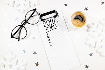 New year resolutions 2026 on desk. 2026 resolutions list with notebook, coffee cup on table. Goals, resolutions, plan, action, checklist concept. New Year 2026 template, copy space