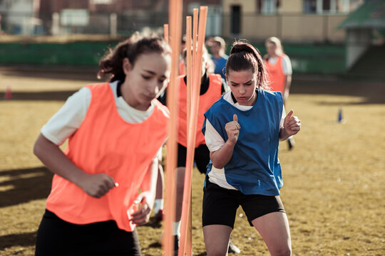 Teen girls soccer team doing agility drills during practice on field