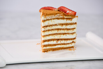 Slice of Classic Medovik Honey Layer Cake layers of honey sponge and creamy filling topped with...