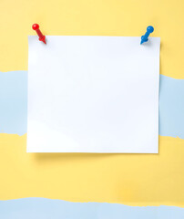 Naklejka premium A blank sheet of paper held in place by pins, offering ample space for personalized notes or important information. Displayed against a vibrant, creative striped background.