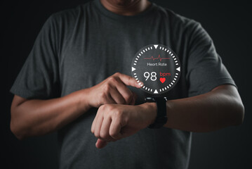 Man using smartwatch with heart rate monitor interface, representing wearable health technology and...