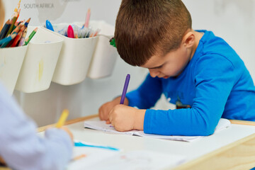 Sweet Boy Learning to Write His First Letters in the Warmth of His Room.