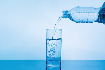 pouring water from the bottle into a glass
