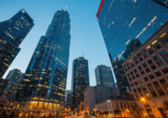 Obraz premium Cityscape featuring illuminated skyscrapers against a twilight sky. Urban architecture showcases a modern skyline with office buildings and commercial development at dusk.