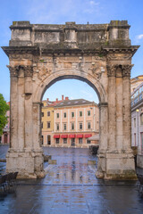 Obraz premium Historic Roman Gate in Pula, Croatia showcasing ancient architecture and scenic surroundings