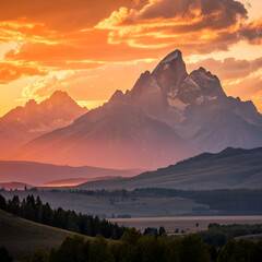 Fototapeta premium Majestic mountain range silhouetted by a golden sunset with dramatic orange and red skies