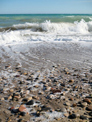 Playa de rocas con olas llegando con poca profundidad de campo