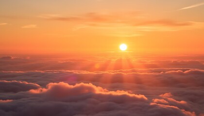 A view of the sun shining brightly above a sea of clouds during a vibrant orange and yellow sunset