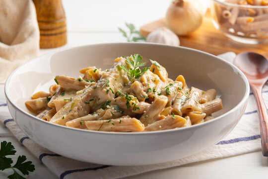 alfredo chicken pasta,Alfredo sauce with cooked penne rigate pasta in creamy sauce and juicy chicken in white plate. - Powered by Adobe