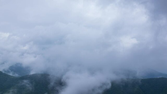タイムラプス　雨の日の山頂を、覆いかぶさりながら流れていく雨雲