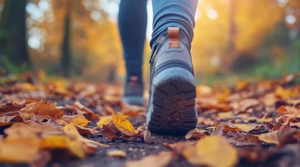 Fototapete Rund Person Walking on a Leaf-Covered Pathway During Autumn Season in a Forest Setting © Benzbutter