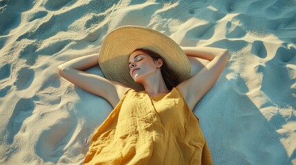 Young woman relaxing on sandy beach wearing summer hat and dress