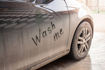 Close-up of a dirty car door with a handwritten 