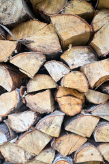 Fototapeta premium Stack of birch firewood with hand chopping block. Chopped firewood for winter. Lot of firewood - harvesting wood for heating the house. Horizontal photo. Chopped firewood background and texture.