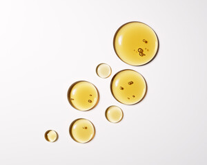 High-quality close-up of golden liquid oil drops isolated on white, 3d rendering face serum cosmetic beauty product design elements