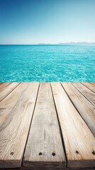 Weathered wooden planks arranged on sandy beach with clear blue ocean and bright daylight background.