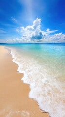 Ocean wave rolling onto sandy beach under clear blue sky during daytime.
