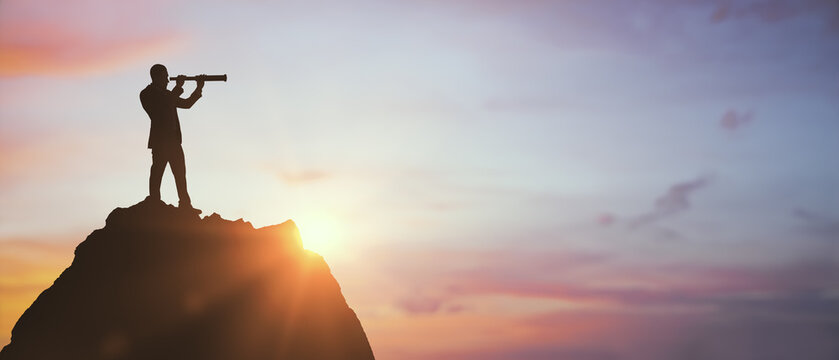 Silhouette of business person with telescope on mountain peak at sunrise, symbolizing vision and leadership in strategic planning and success.