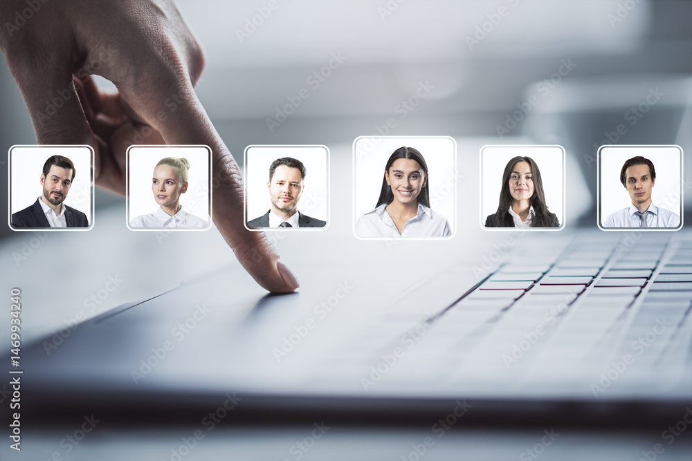 Poster hand selecting employee profile on digital interface above laptop keyboard with businesspeople portr