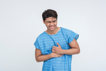 Young Southeast Asian male grimacing and holding chest, indicating sudden severe pain, possibly...