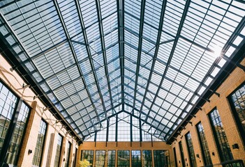 A large glass roof in a building with many windows.