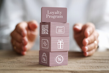 Stacked wooden cubes display loyalty program concept with icons: QR code, document, gift, shopping bag, percentage discount, symbolizing rewards and benefits