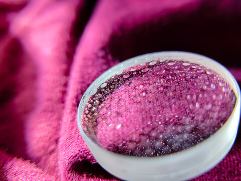 Fototapeta close up of a convex lens with water droplets on an insulated cloth