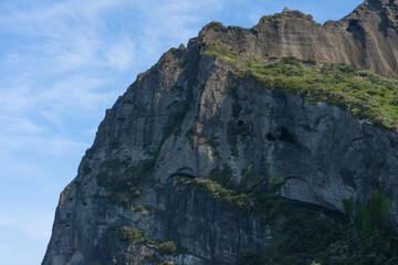 Seongsan Ilchulbong volcanic cliff in natural daylight, rugged textures, Jeju, South Korea landscape, blue sky backdrop, no person