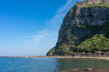 Seongsan Ilchulbong volcanic cliff, bright mood, coastal landmark with ocean and blue sky, Jeju, South Korea