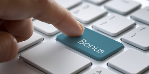 Close-up of finger pressing teal Bonus key on white keyboard, illustrating online reward or incentive concept