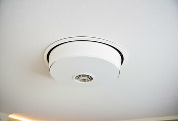 A smoke detector mounted on the ceiling of a room.