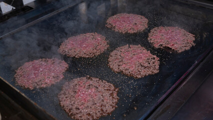 Smash burger patties sizzling on the griddle