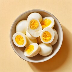 A bowl of perfectly boiled eggs on a bright yellow background