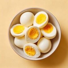A bowl of perfectly boiled eggs on a bright yellow background